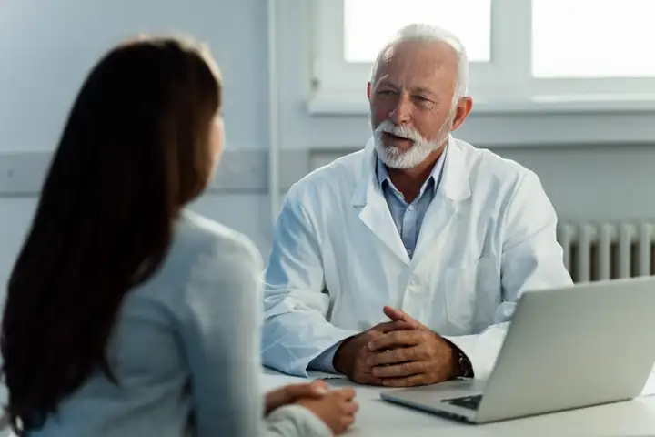 Doctor talking with a patient across a desk