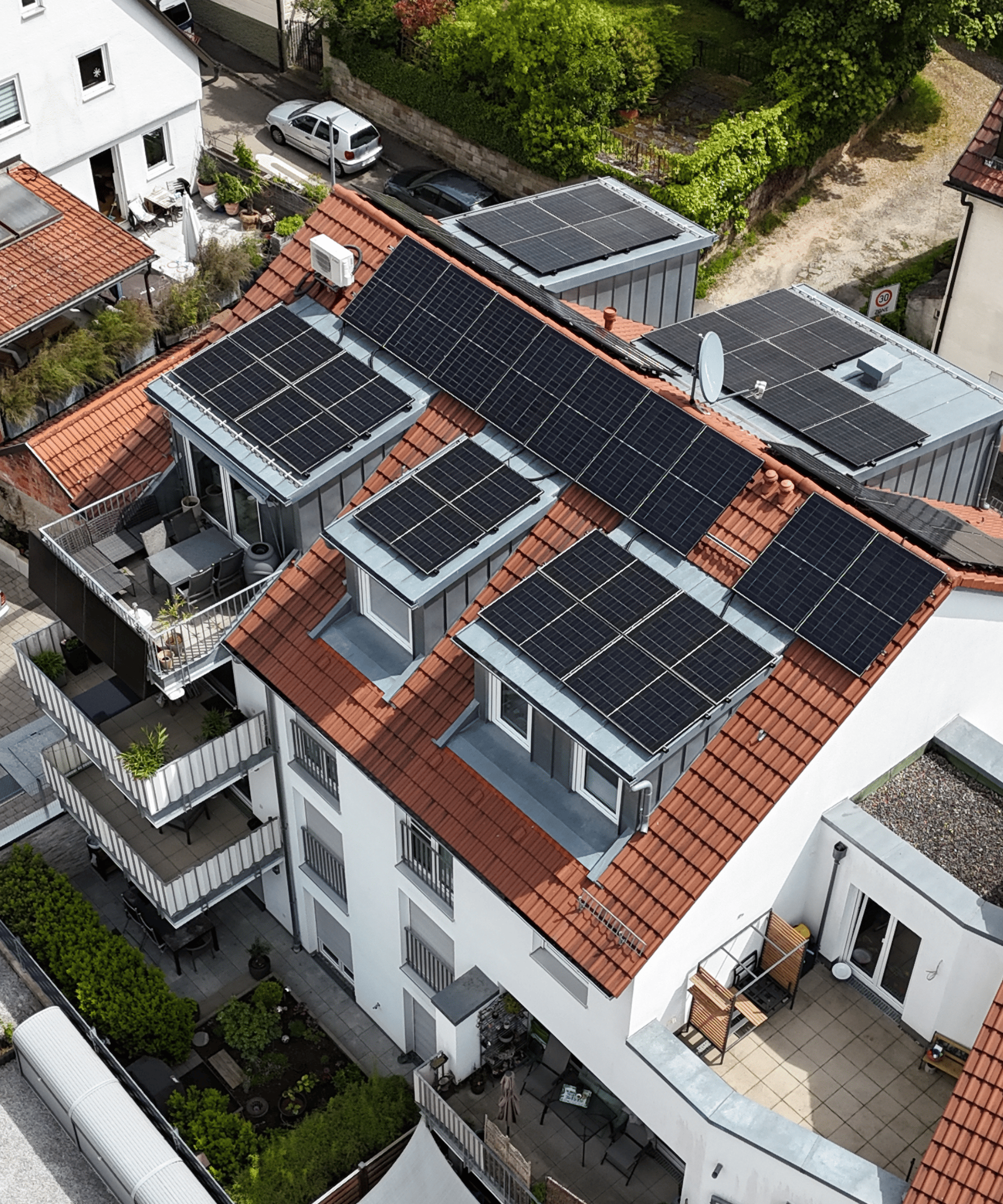 Photovoltaikanlage auf modernem Mehrfamilienhaus in Großheppach mit Solarmodulen auf mehreren Dachflächen auf der Westseite. Luftaufnahme einer energieeffizienten Wohnimmobilie mit nachhaltiger Solarenergie, PV-Anlage und moderner Dacharchitektur in urbaner Wohnlage.