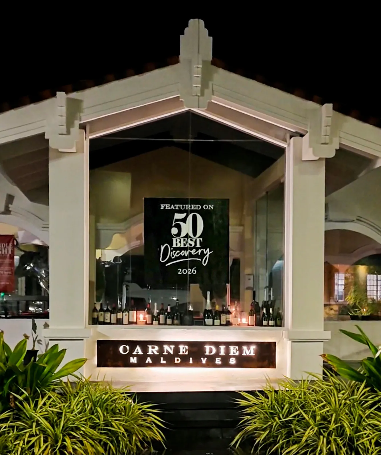 Carne Diem Grill entrance at night with a sign reading Featured on 50 Best Discovery 2026