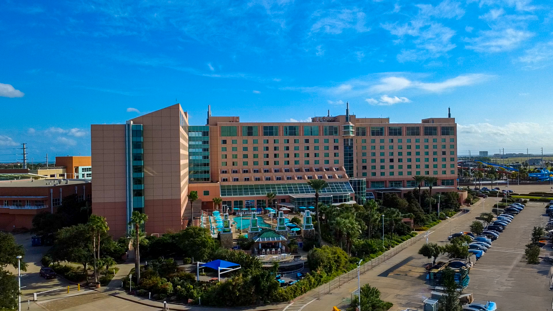 The pool at the Moody Gardens Hotel filled with hotel guests enjoying a sunny day out and the text Spring Sale 25% Off Best Available Rate