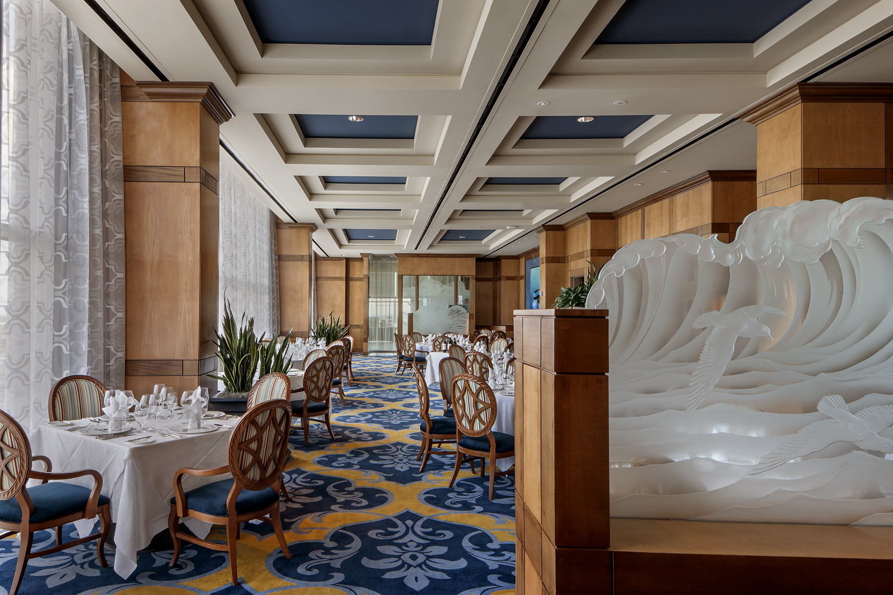 Shearn's dining room with coffered ceilings and a white sculpted wave wall