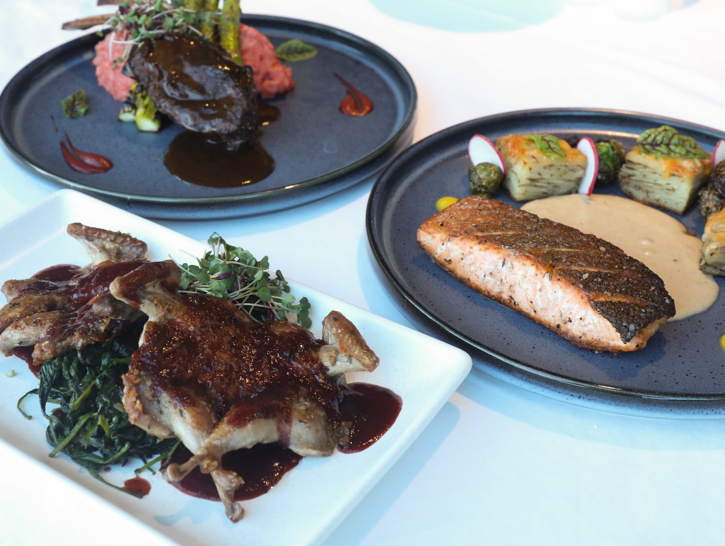 Plated entrees at Shearn's including seared salmon and braised short rib