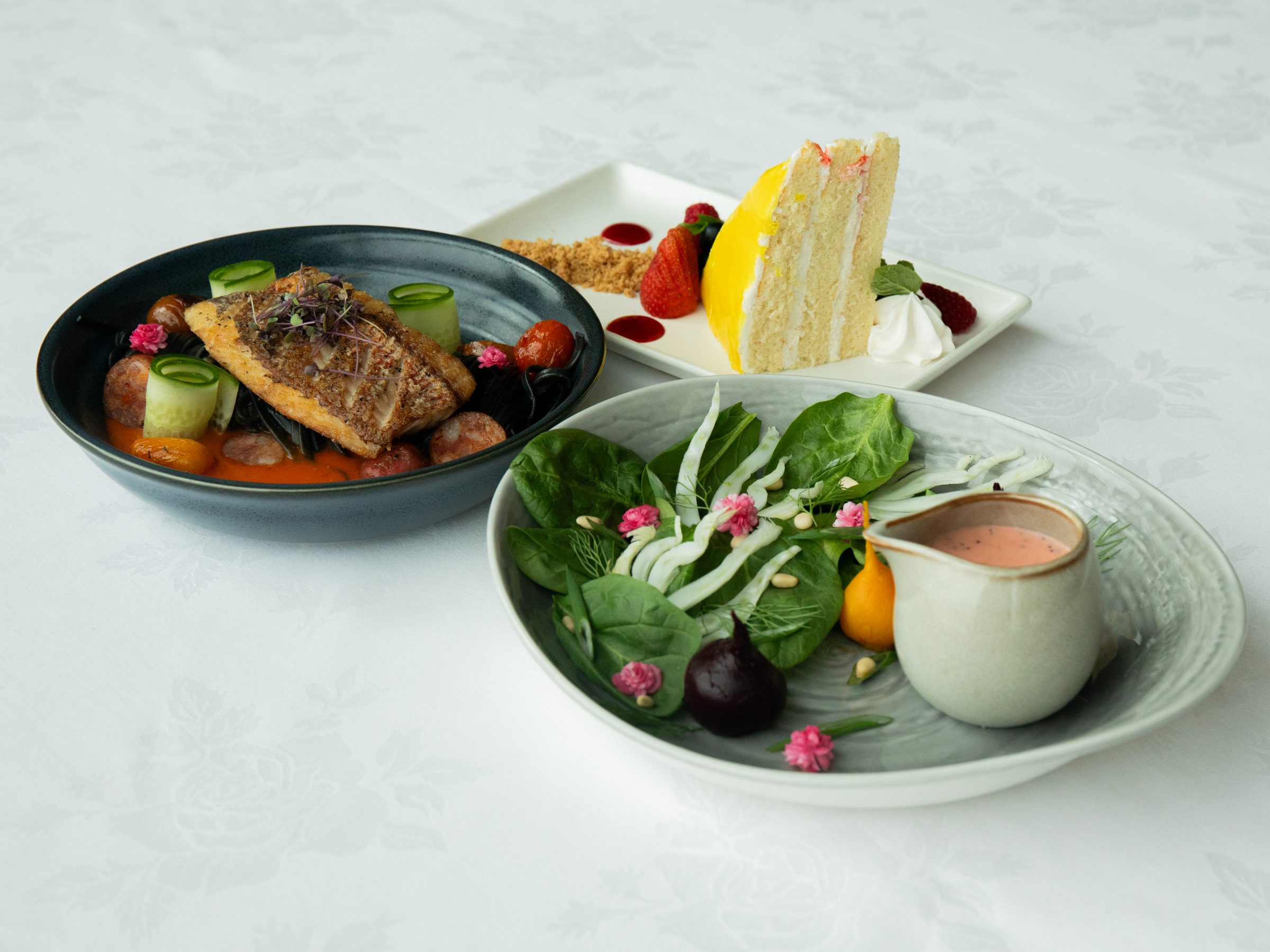 Seared fish, a spinach salad, and a slice of layer cake at Shearn's