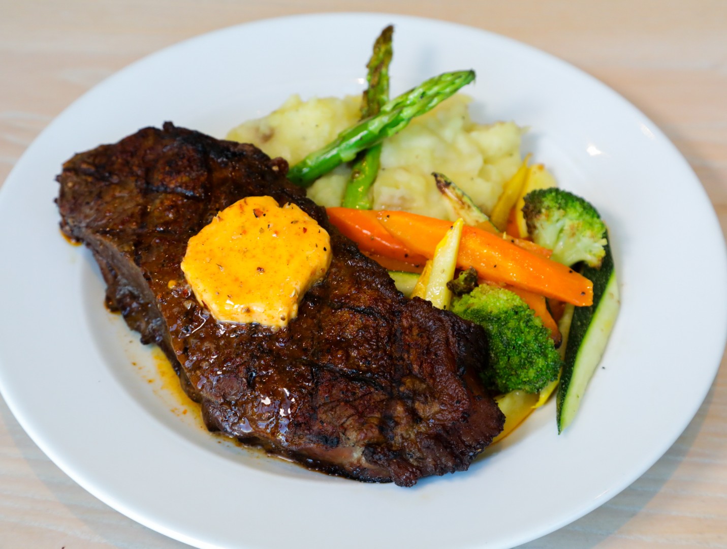 Grilled steak with herb butter, mashed potatoes, and vegetables at Café in the Park