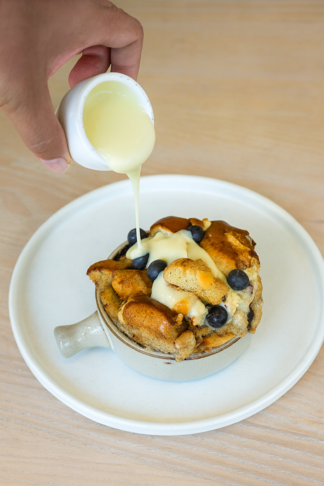Warm sauce poured over bread pudding at Café in the Park