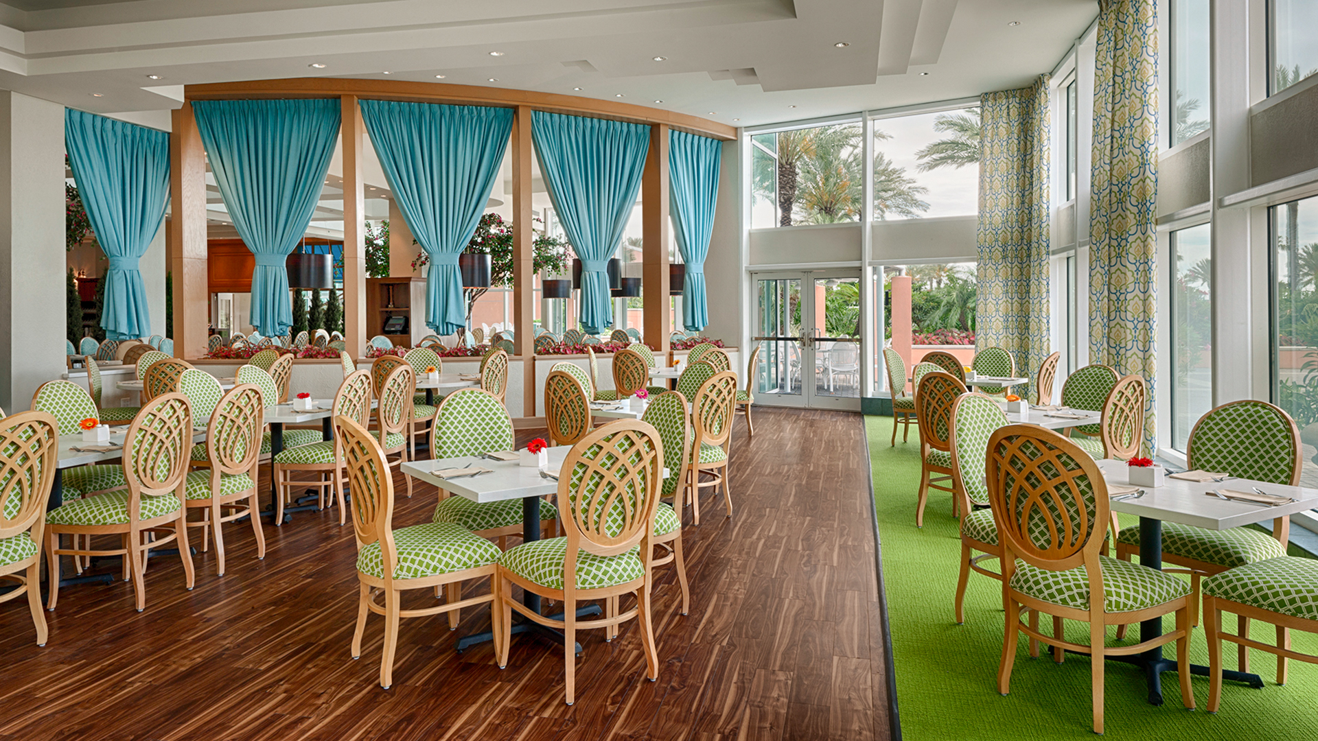 Café in the Park dining room with teal curtains and garden-green floors