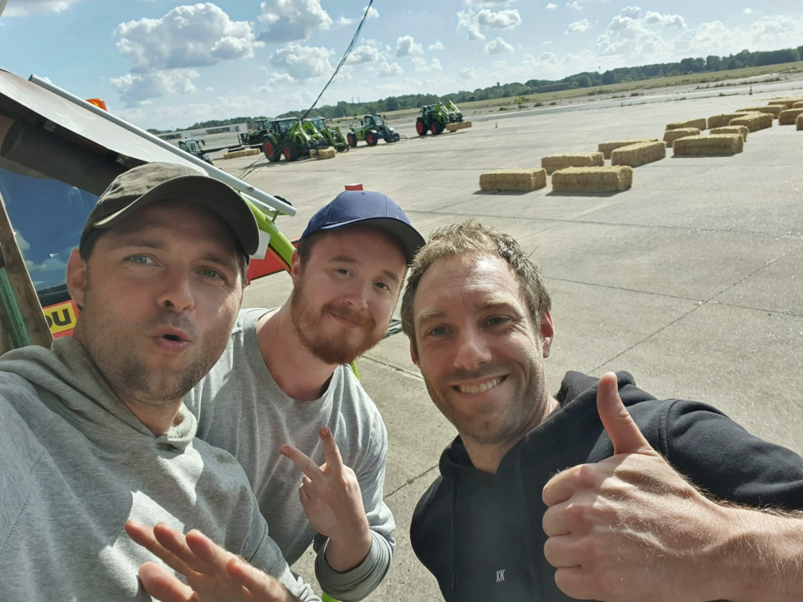 Kopfkunst-Mitarbeiter Max Klas und Simon Kraft lachen zusammen mit Claas-Mitarbeiter Ben in die Kamera.