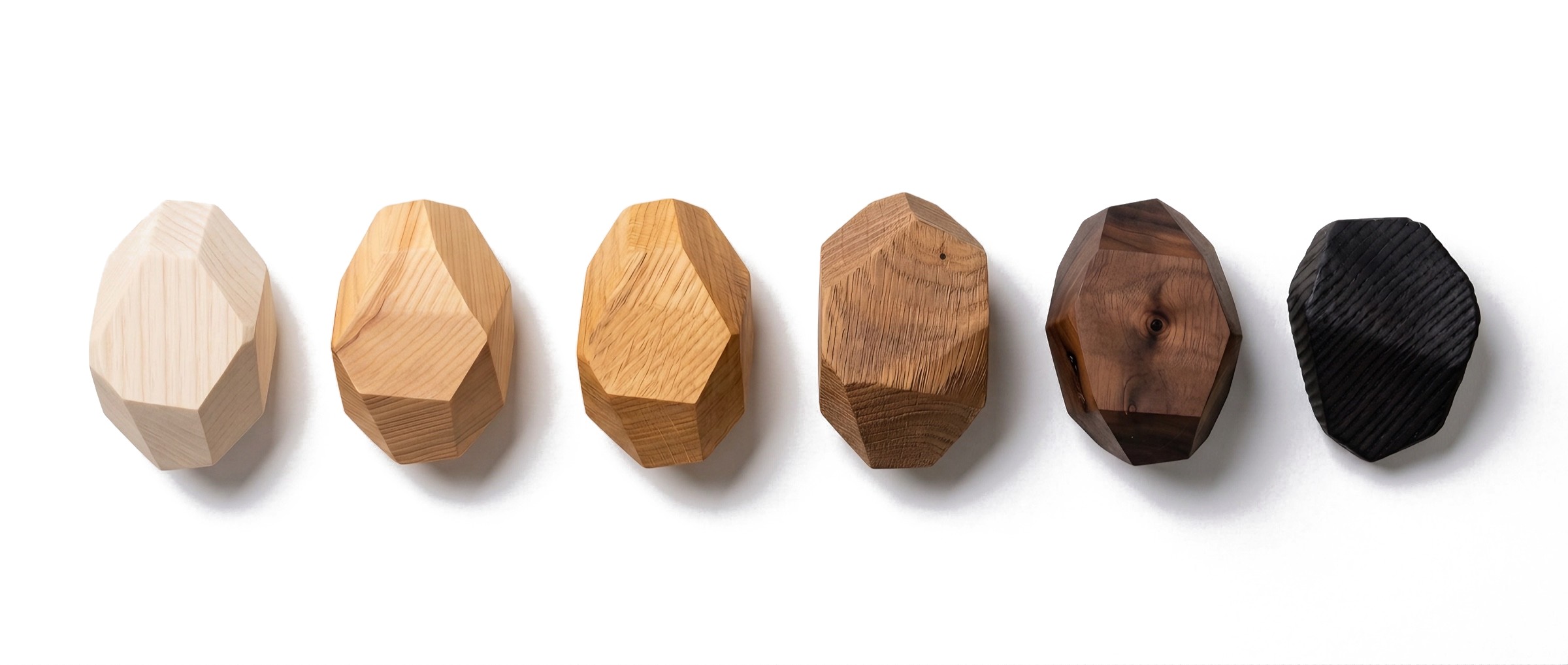 Six Anonymia® sample stones in a row, from left: bleached ash, oiled ash, oiled oak, sandblasted oak, walnut and yakisugi