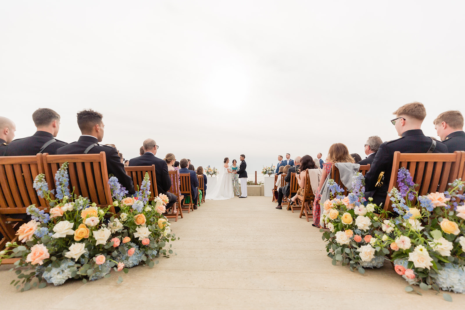 An outdoor wedding ceremony with the couple at the altar as live music plays