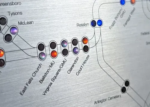 A close-up of the Metroboards brushed aluminum front panel, with lit LEDs and printed tracks/stations.