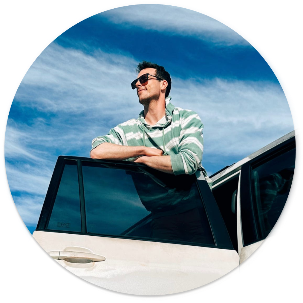 craig tyner, with sunglasses riding in a jeep on a sunny day