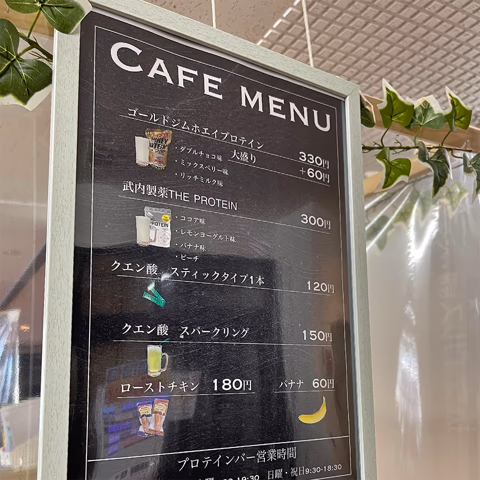 カフェメニュー：ゴールドジムホエイプロテイン（330円、増量＋60円）、武内製薬THE PROTEIN（300円）、クエン酸スティックタイプ1本（120円）、クエン酸スパークリング（150円）、ローストチキン（180円）、バナナ（60円）の価格と商品写真。