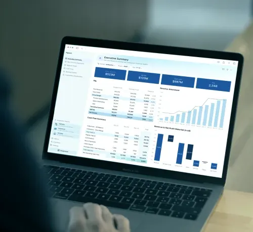 MacBook Pro displaying a financial dashboard with revenue, EBITDA, cash, and profit charts and tables.