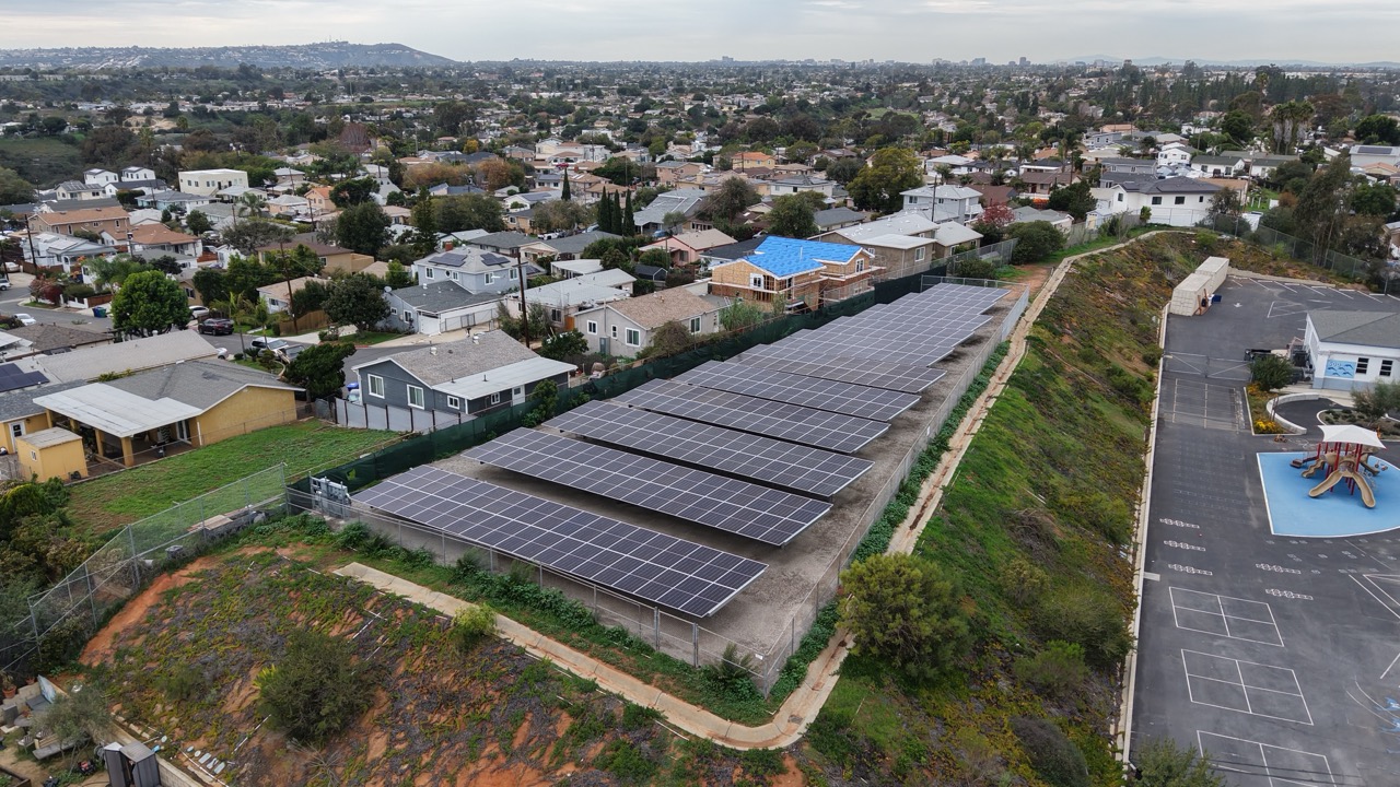 Aerial view of a solar ground mount installation at a school. Aerial drone image of solar carport installation at Linda Vista Elementary supporting SDUSD commercial solar initiatives.