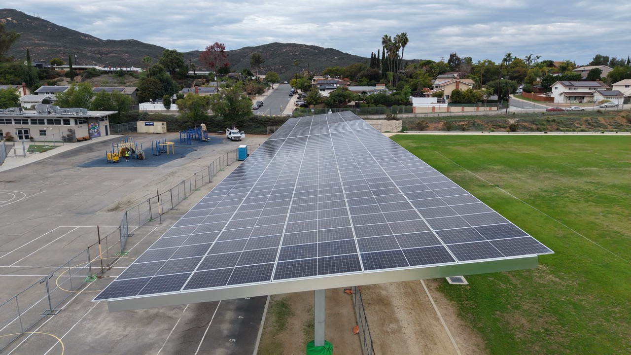Aerial drone perspective of a DSA solar project at Gage Elementary School showcasing commercial solar carport installation for SDUSD.