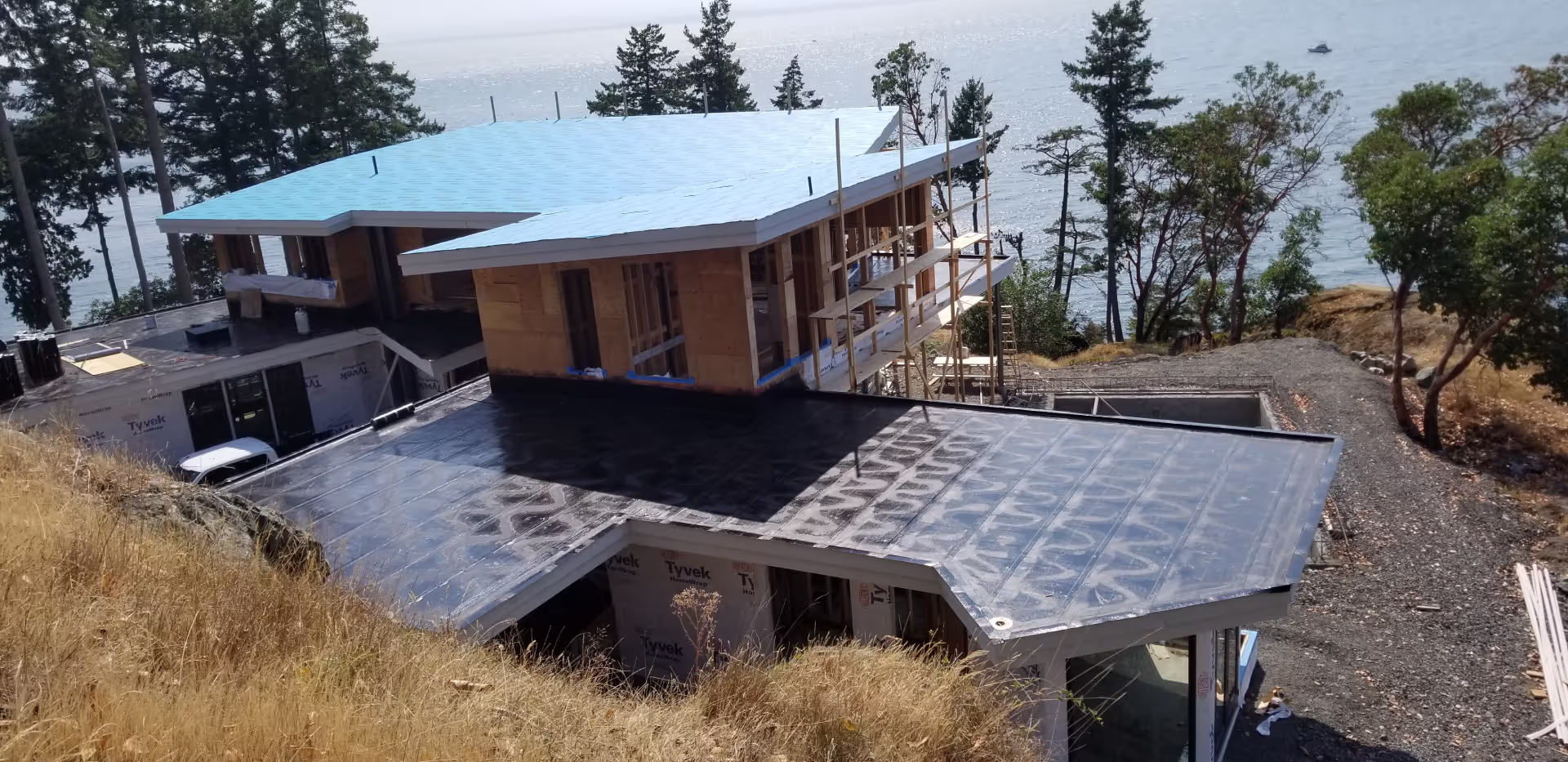 Bowen Island — waterfront home on a rocky bluff with torch-on membrane going onto the lower roof
