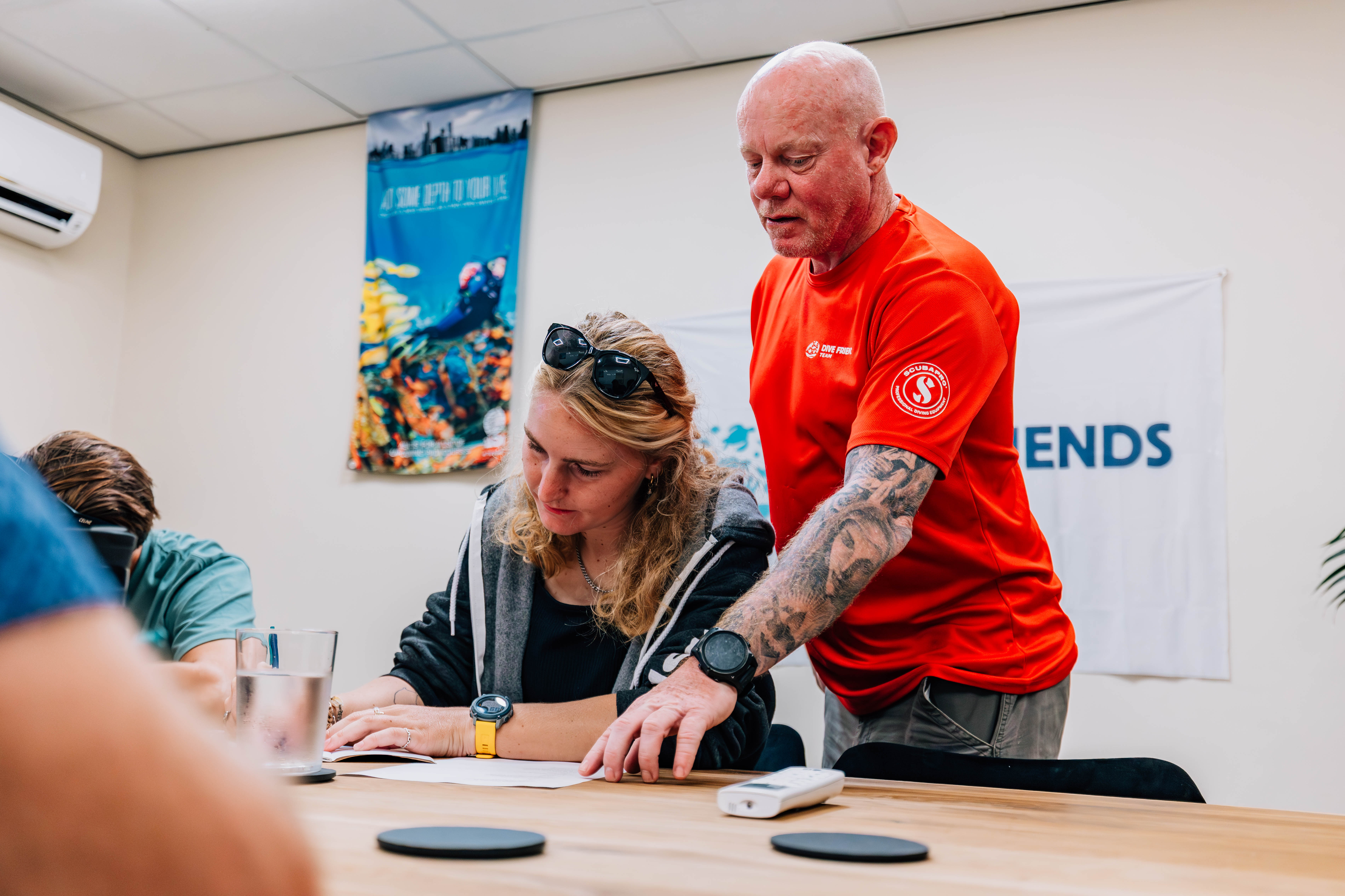PADI instructor coaching a student in the classroom