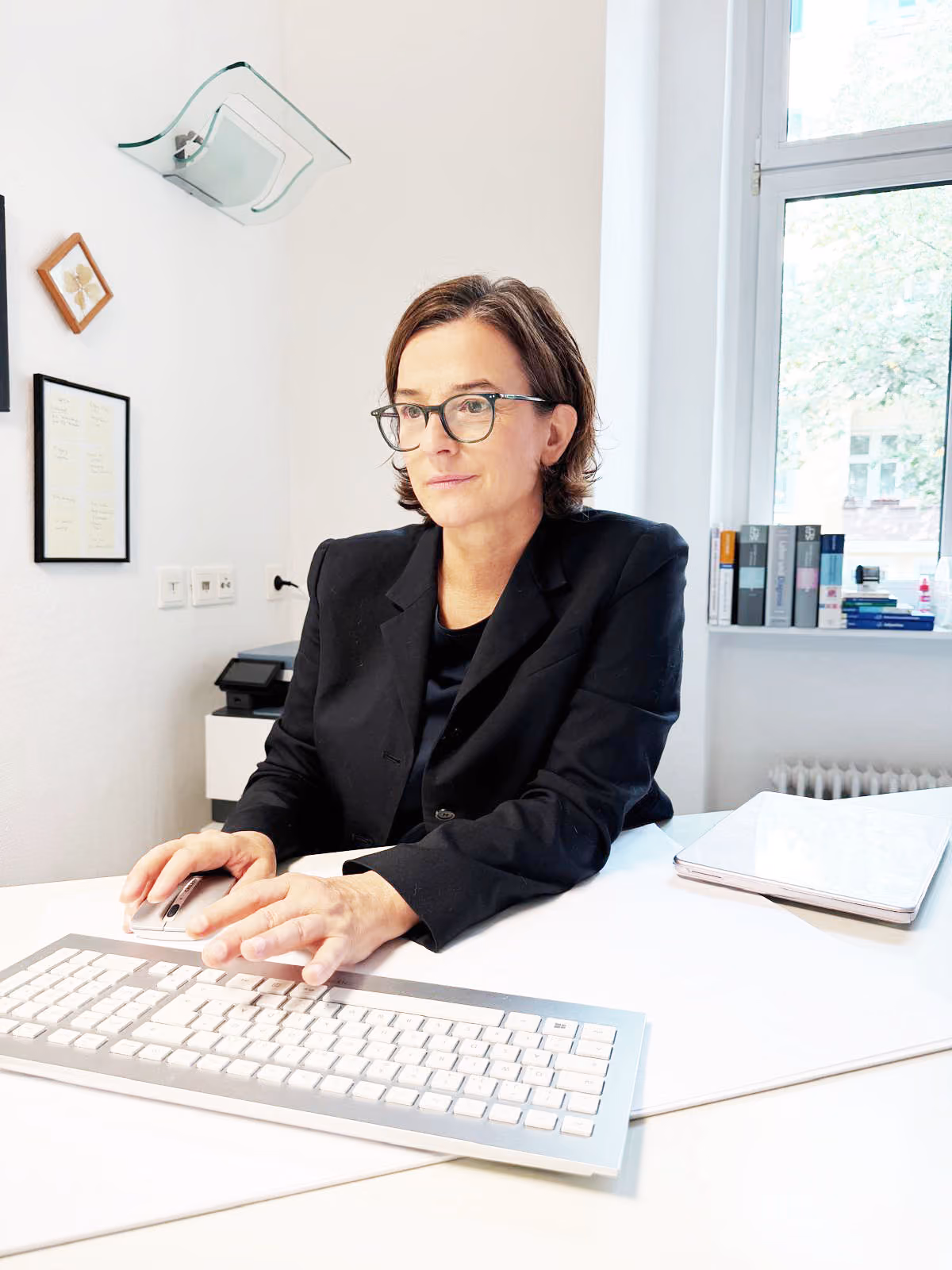 Heller Behandlungsraum in der Praxis von Daniela Kielkowski mit Sitzgruppe und Schreibtisch