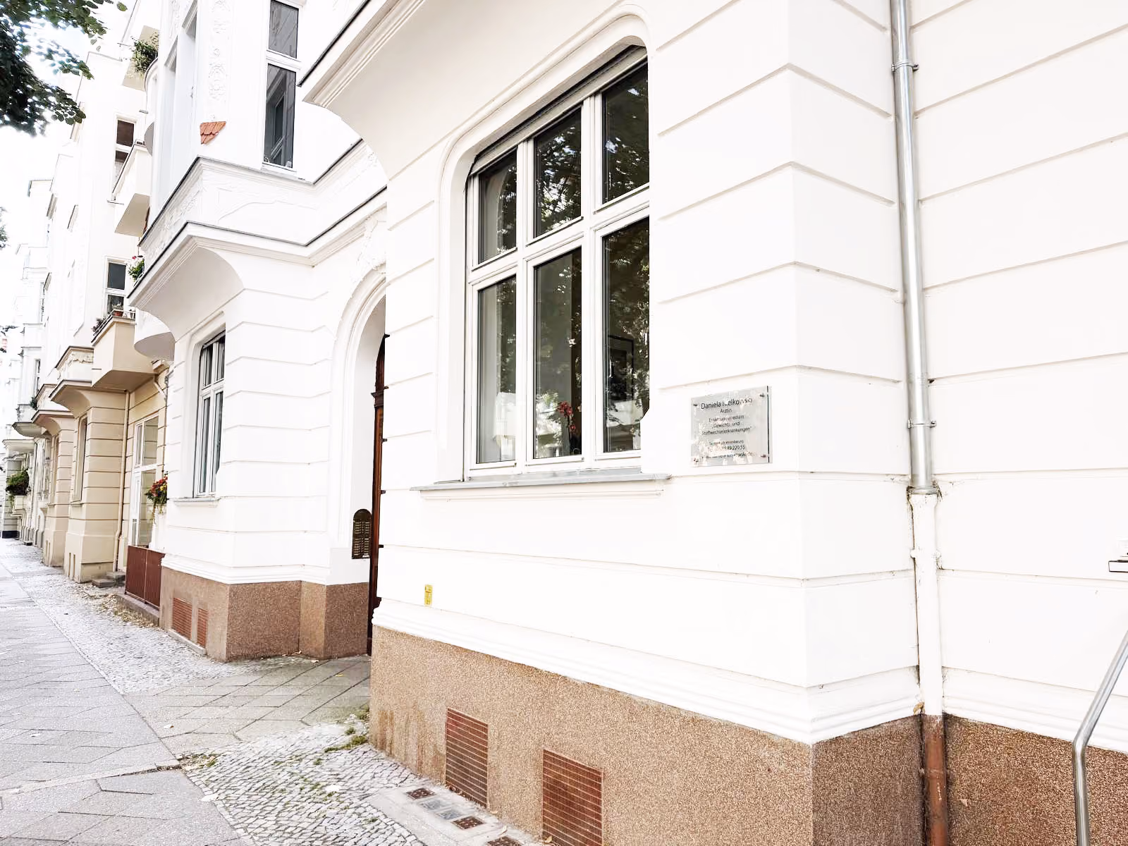 Heller Behandlungsraum in der Praxis von Daniela Kielkowski mit Sitzgruppe und Schreibtisch