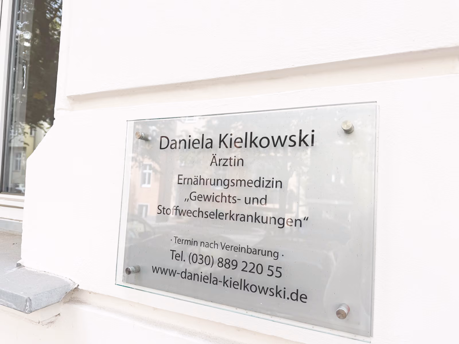 Heller Behandlungsraum in der Praxis von Daniela Kielkowski mit Sitzgruppe und Schreibtisch