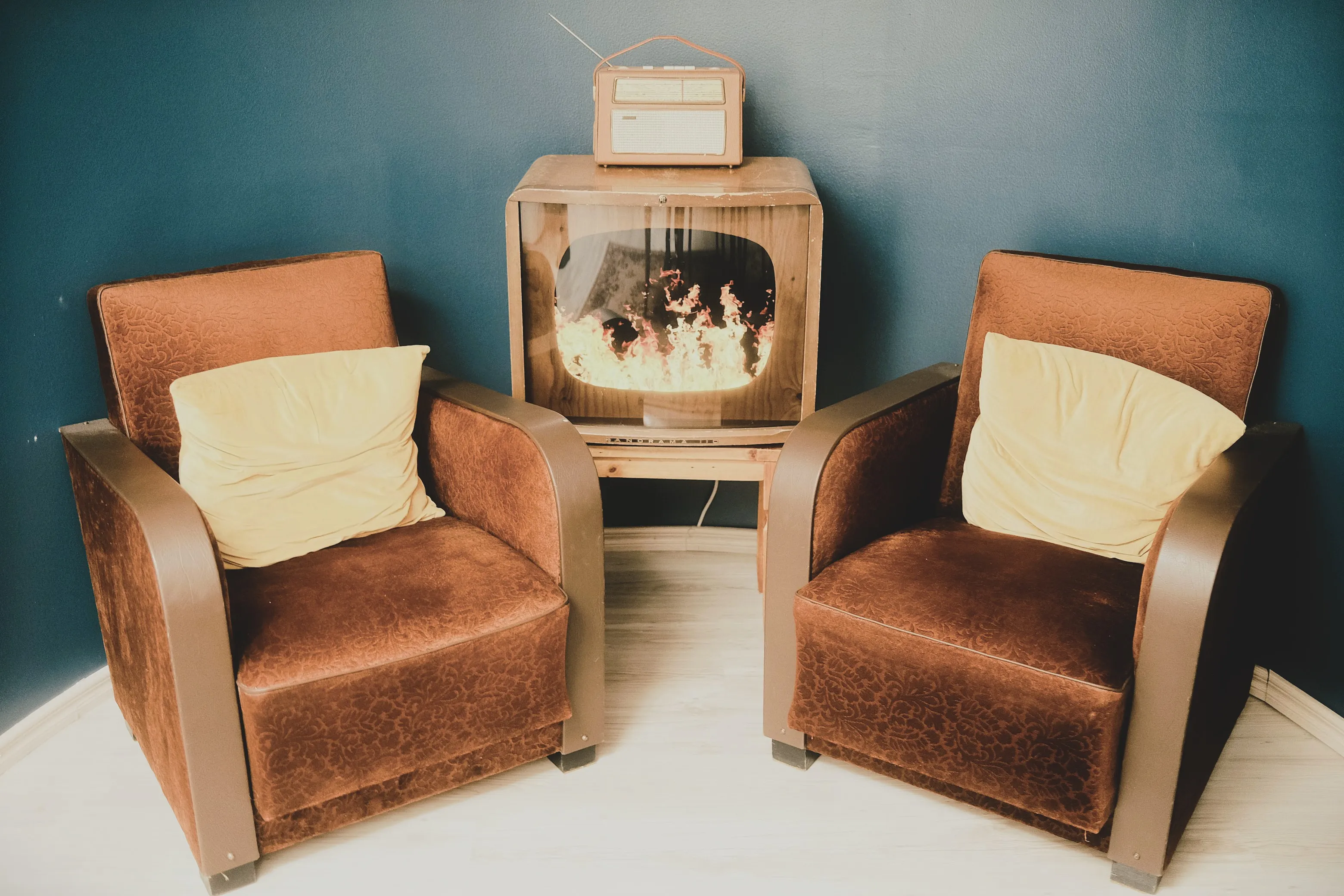 Lualan Turun toimipisteen sisustusta: viihtyisä nurkkaus nojatuoleilla ja takkatulta näyttävällä televisiolla.