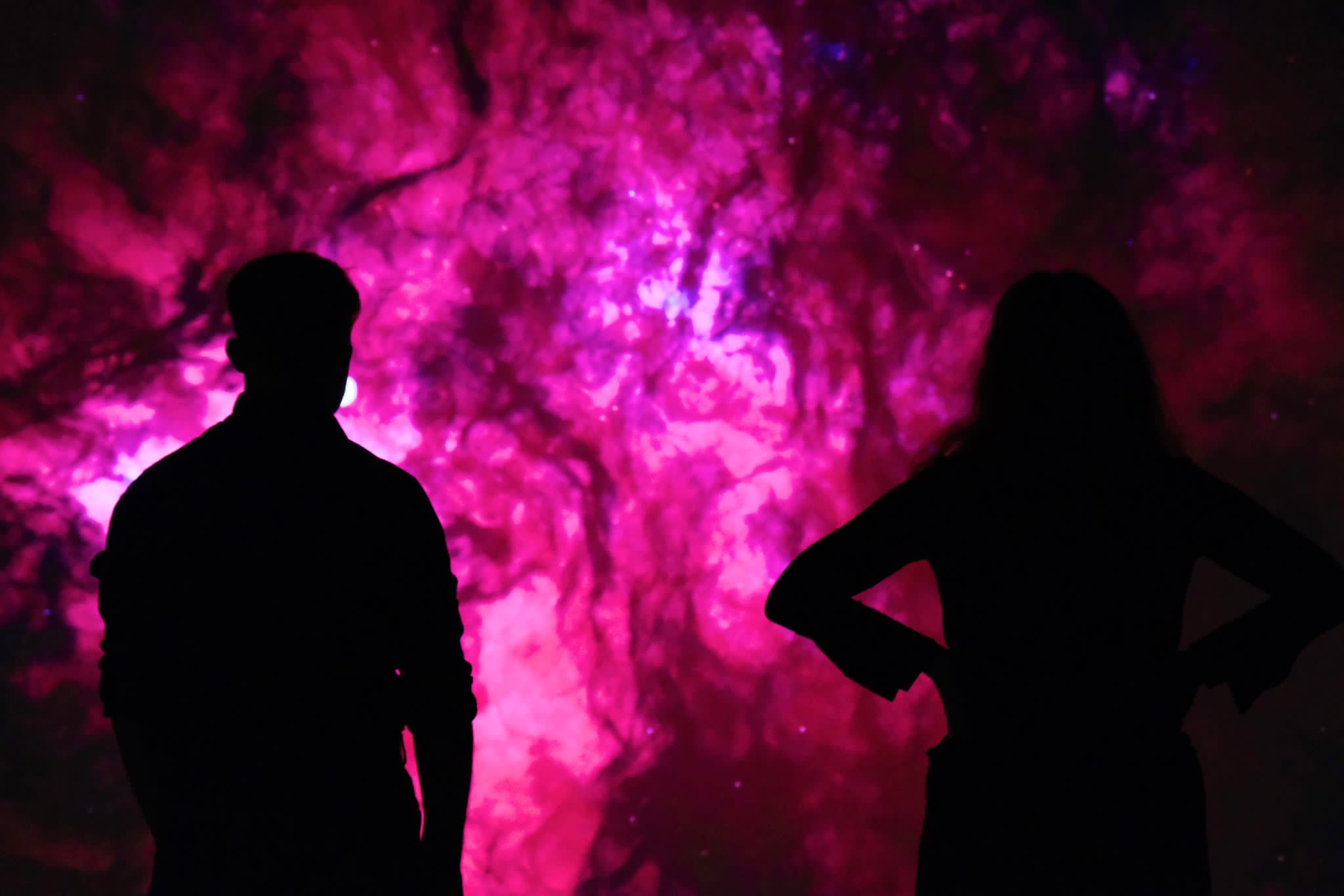 A couple watching the space visuals projected on the wall.