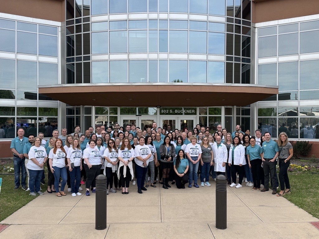 A large group of Miracle-Ear Foundation volunteers gathered outside the Dallas office