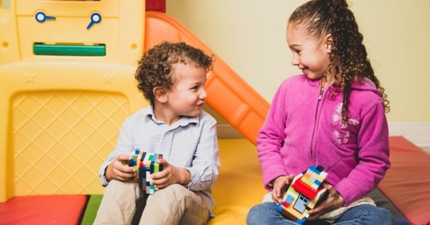 Two happy kids in children's ministry holding toy