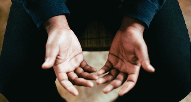 A man in church with open hands ready to give