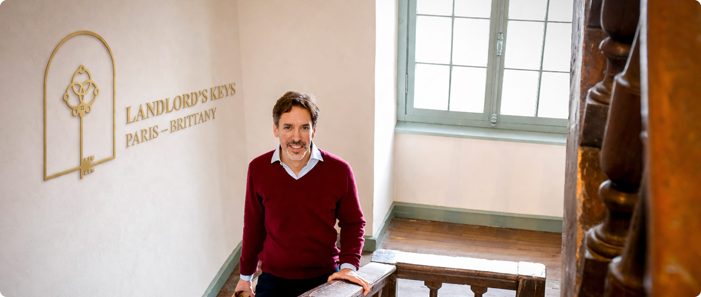 François, founder of Landlord's Keys, standing in front of the company logo in a historic building