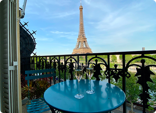 Green bistro chair on a Parisian balcony with Haussmann buildings in the background