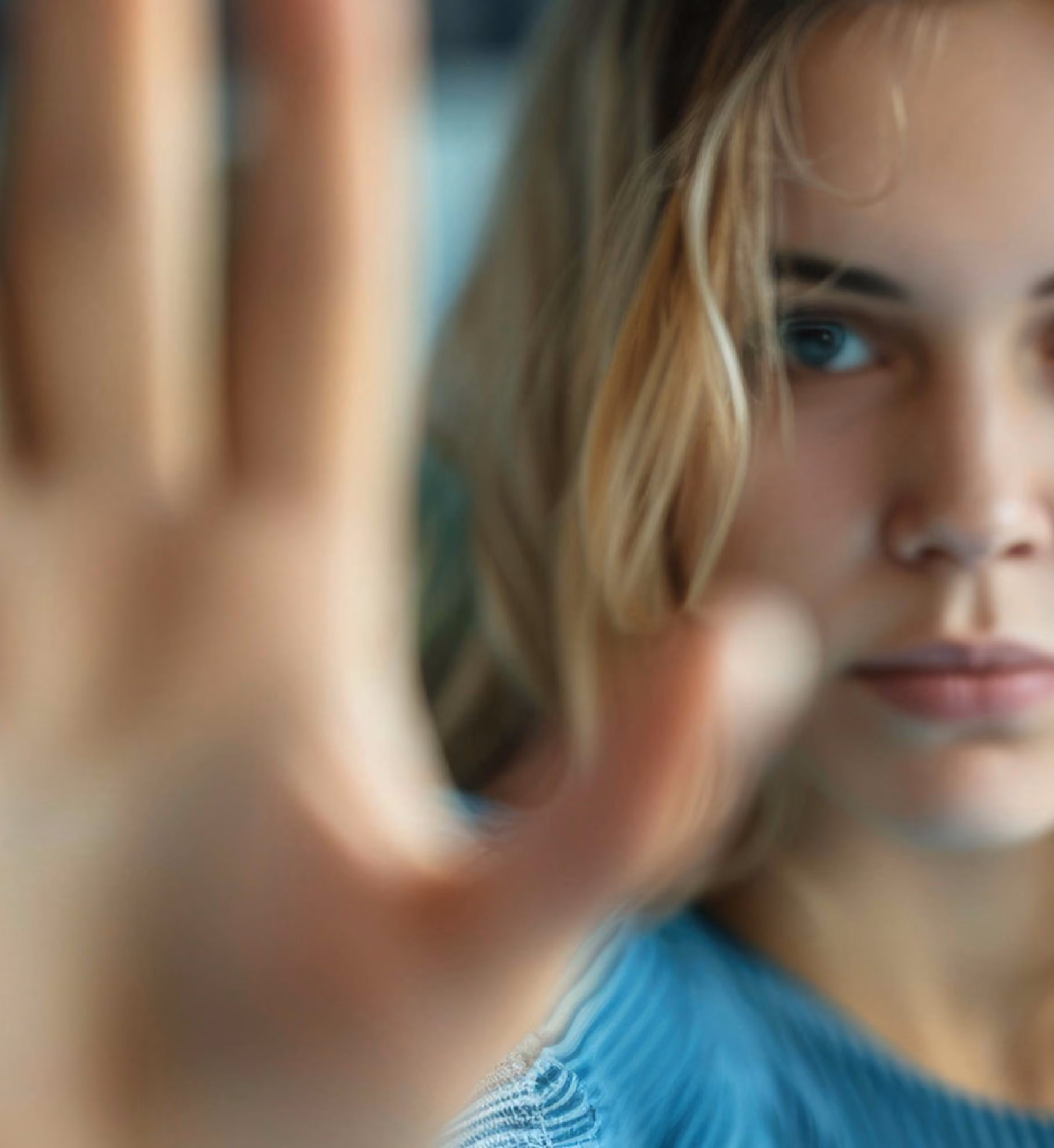 A young lady with her hand raised in the stop position