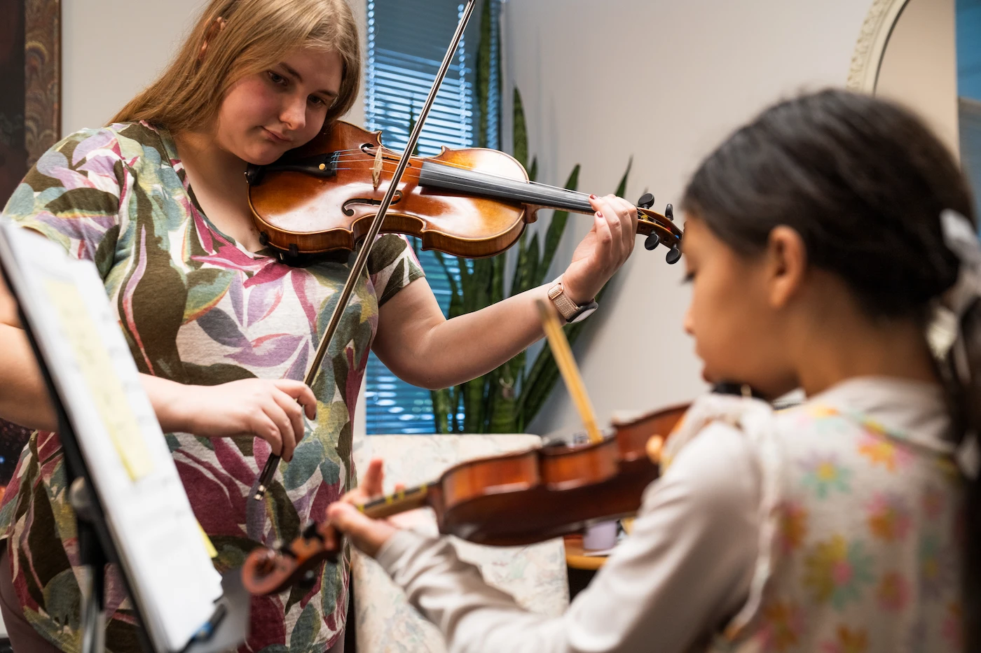 Violin teacher coaching student during ensemble rehearsal at Cincinnati Music Academy.