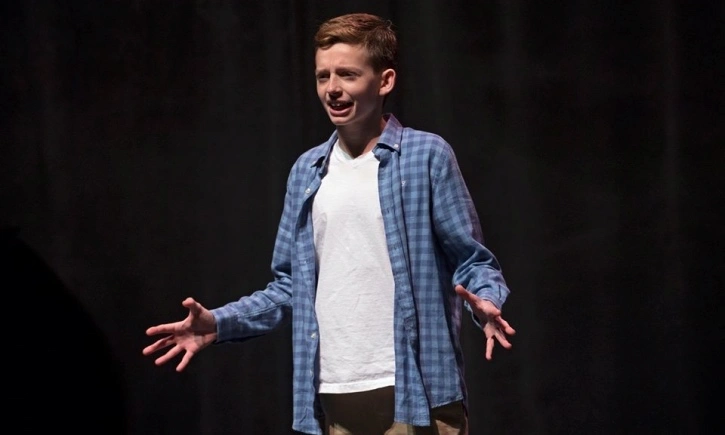 Young acting student performing monologue on stage during private acting lesson showcase at Cincinnati Music Academy.
