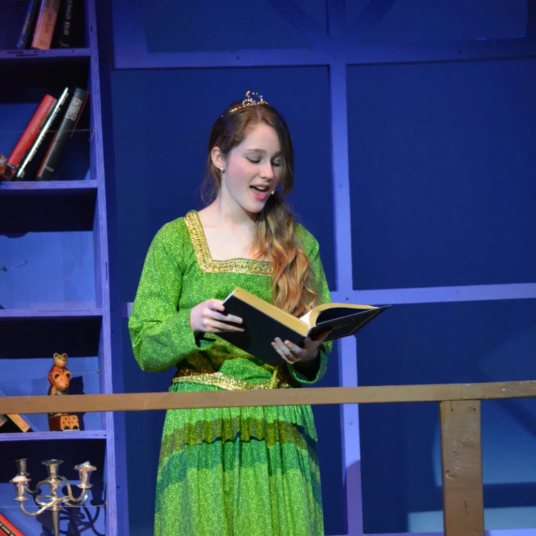 vStudent performing on stage during Cincinnati Music Academy acting recital.