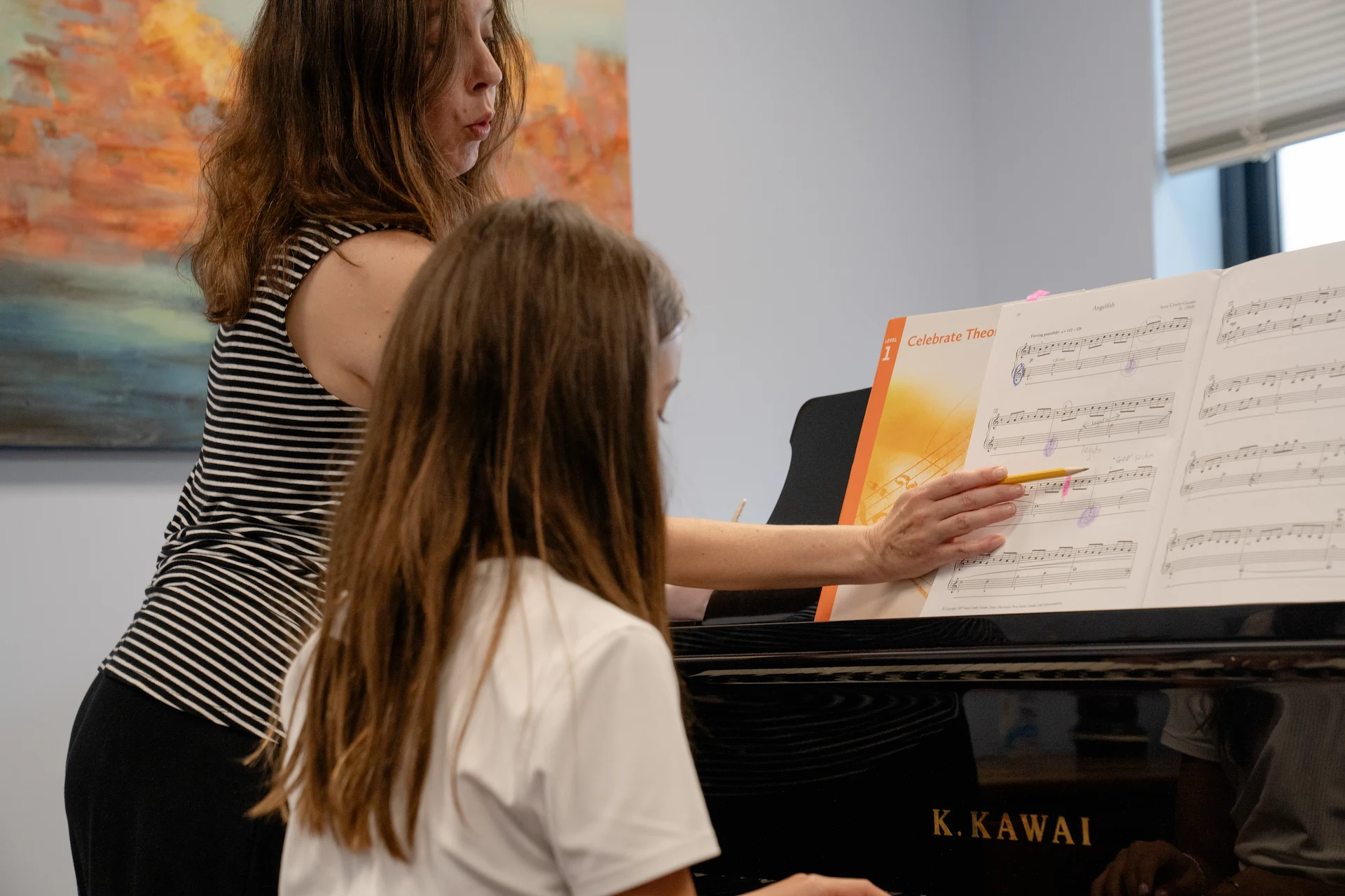 Piano instructor guiding a young student through a lesson at Cincinnati Music Academy.