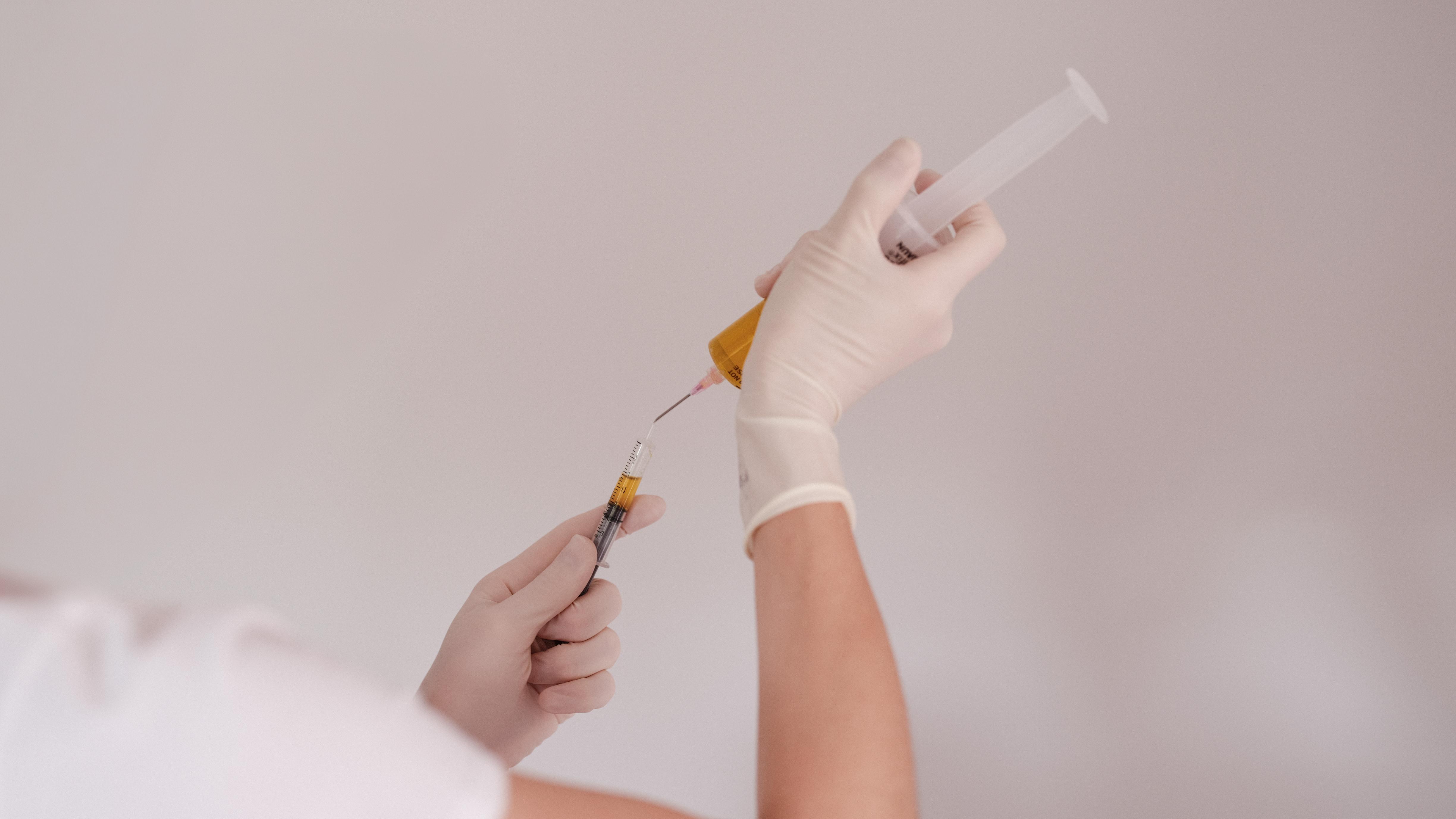 Gloved hands transferring PRP between syringes