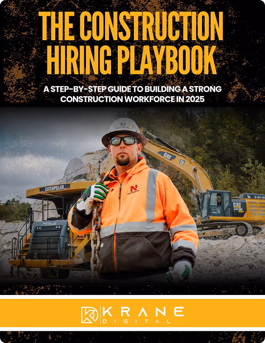 Construction worker in orange jacket and helmet holding a rope in front of yellow Caterpillar excavators at a job site.