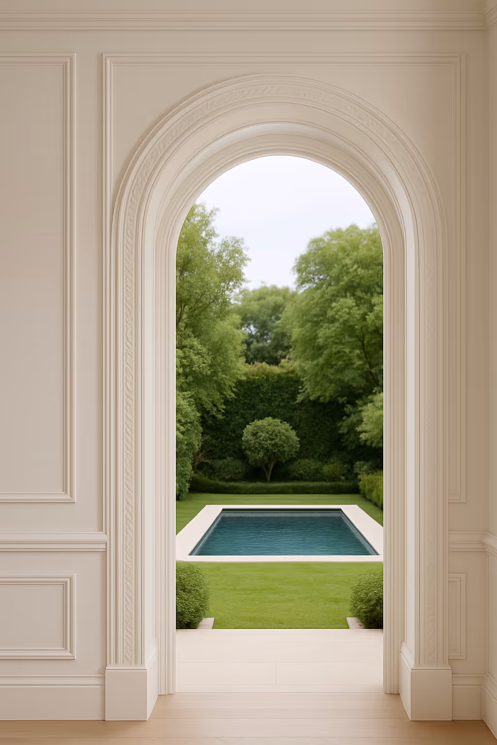 View through an elegant arched doorway showing a garden with trimmed grass, various green trees, and a rectangular swimming pool.