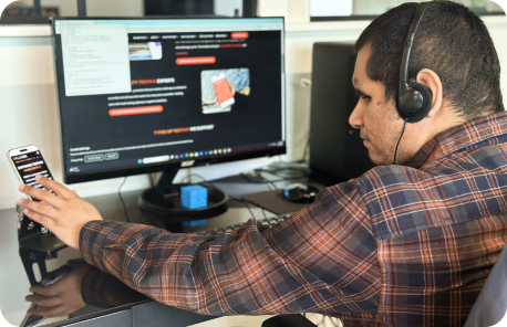 Jesus at his workstation testing a website on both desktop and mobile devices using a screen reader on each.
