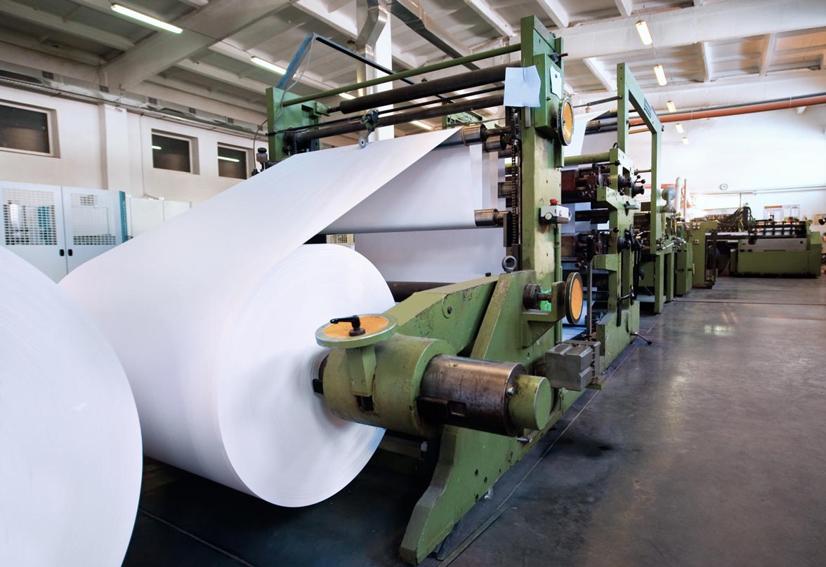 Machinerie lourde et papier dans une usine de pâtes et papiers.