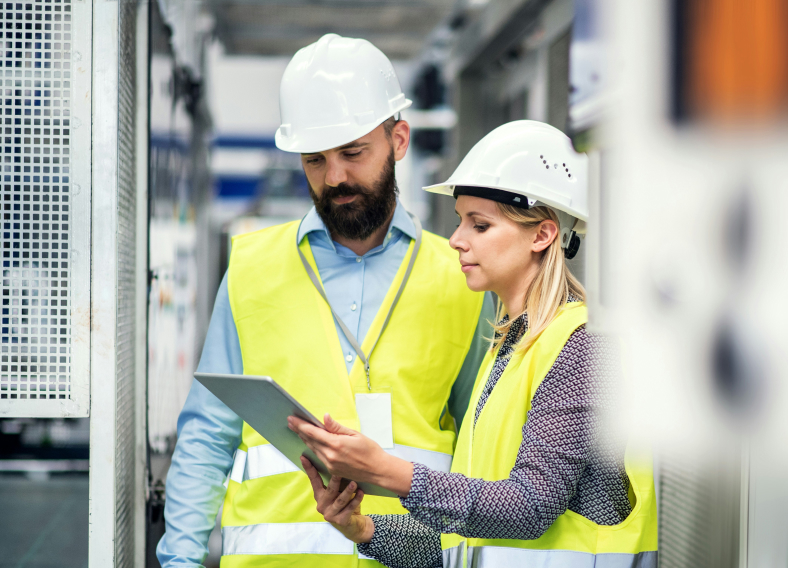 Two workers looking at an industrial machine.