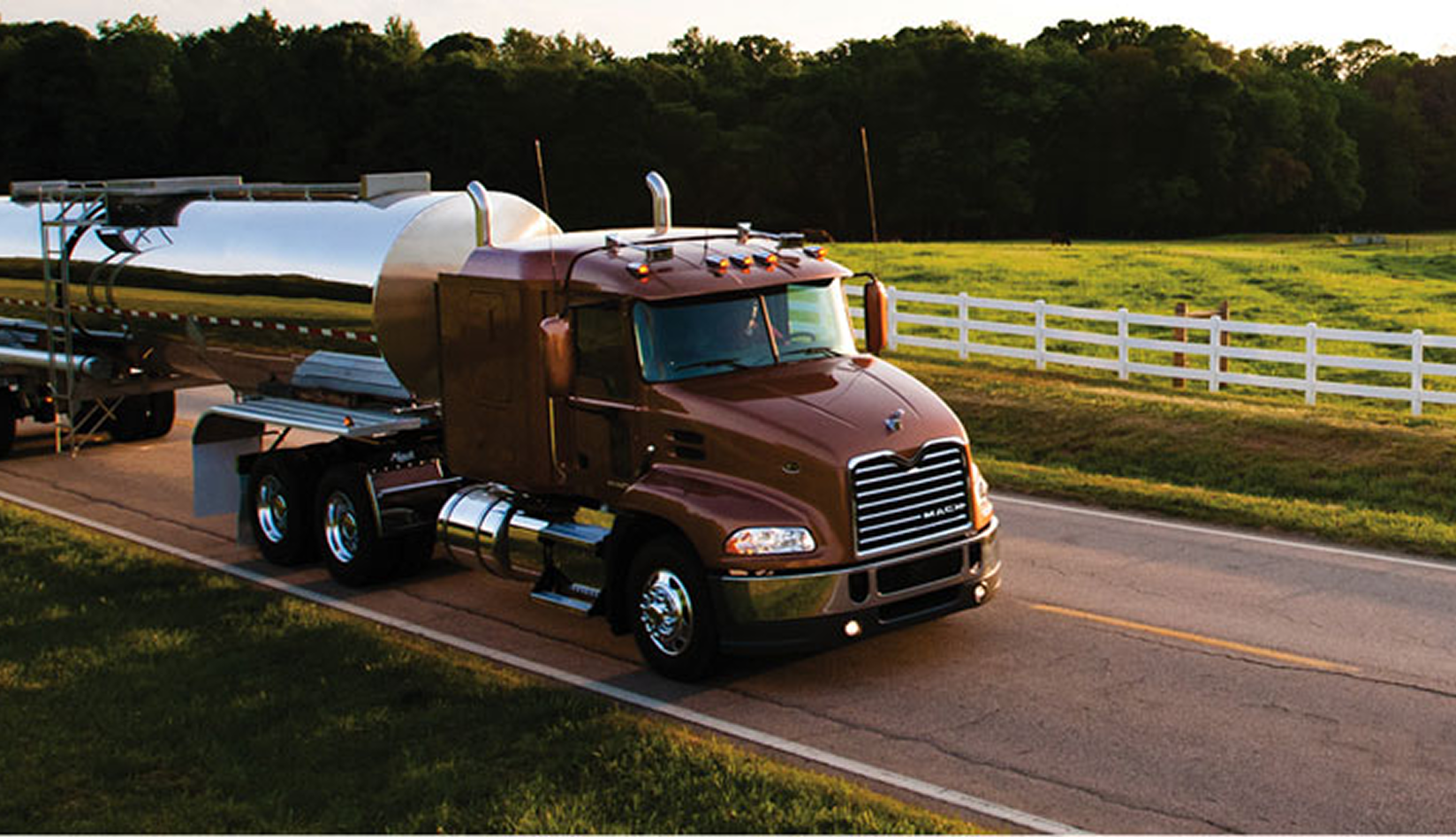 Photo of a red Mack truck on a country road.