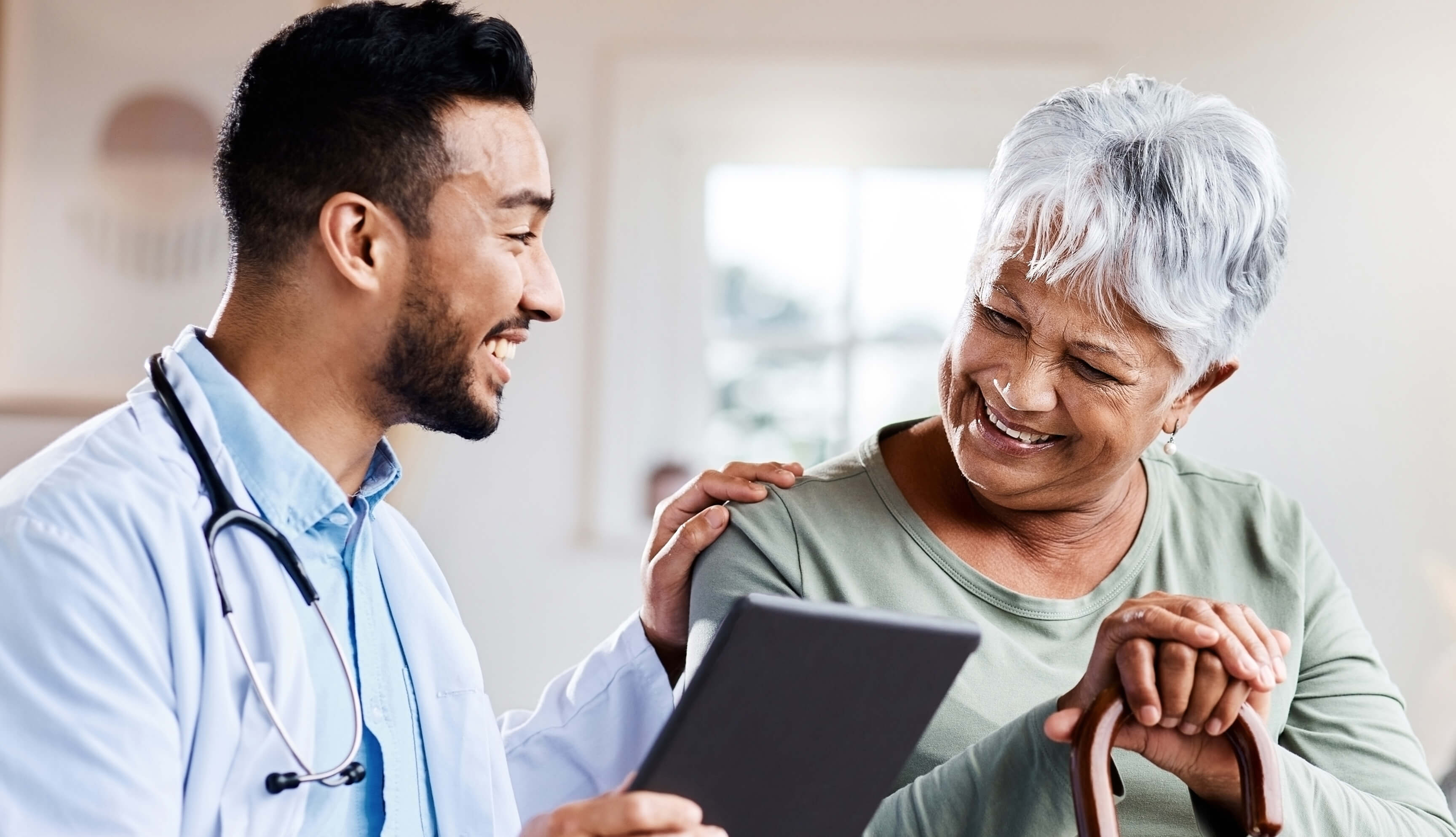 Doctor with an elderly patient, both smiling.