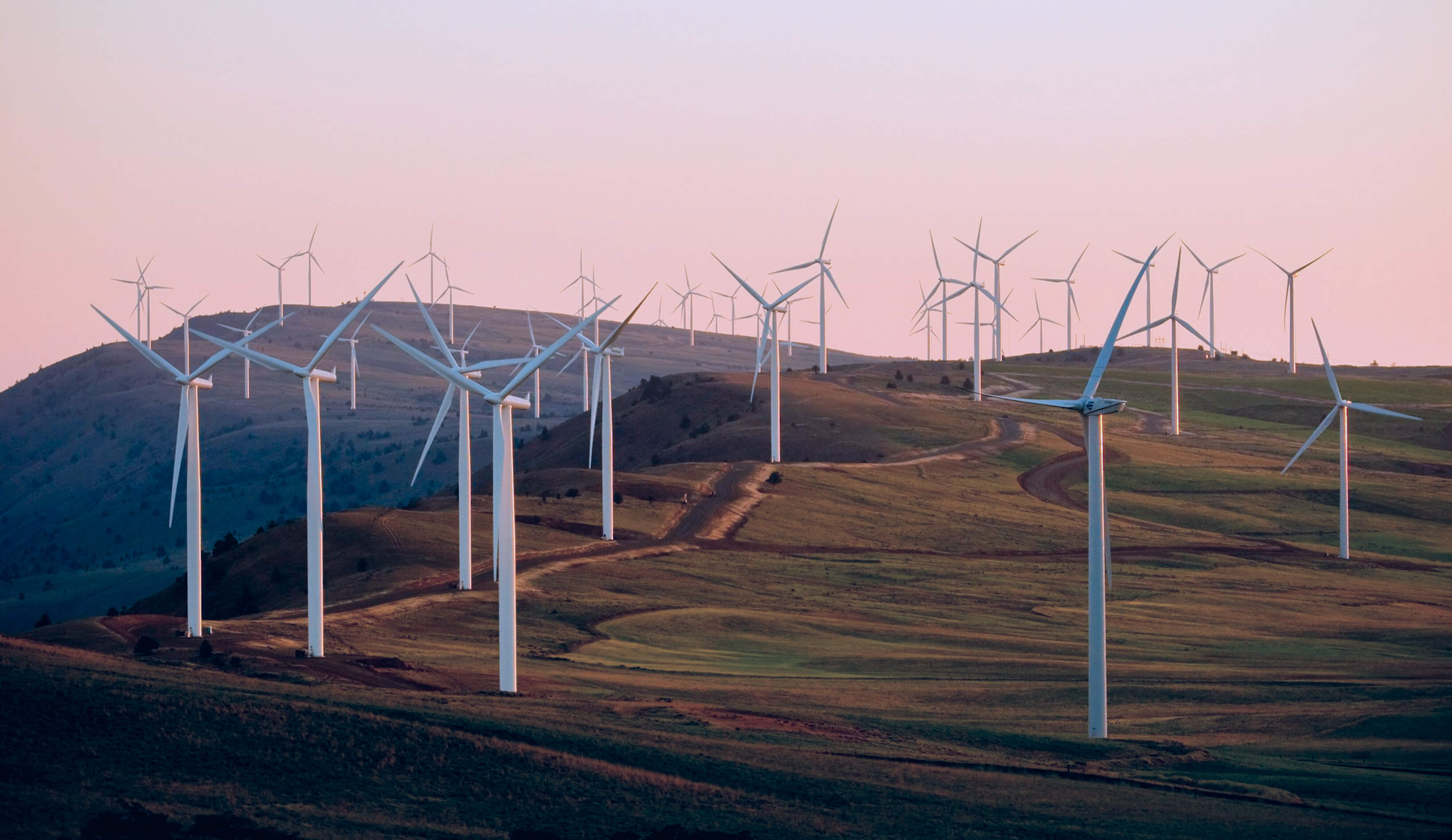 Éoliennes sur un site d’énergie renouvelable entouré d’un paysage ouvert.