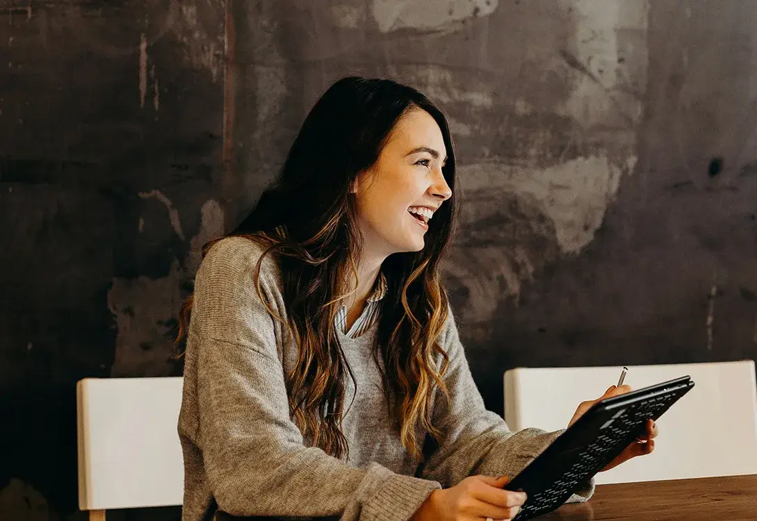 Photo of a girl smiling with tablet in her hands