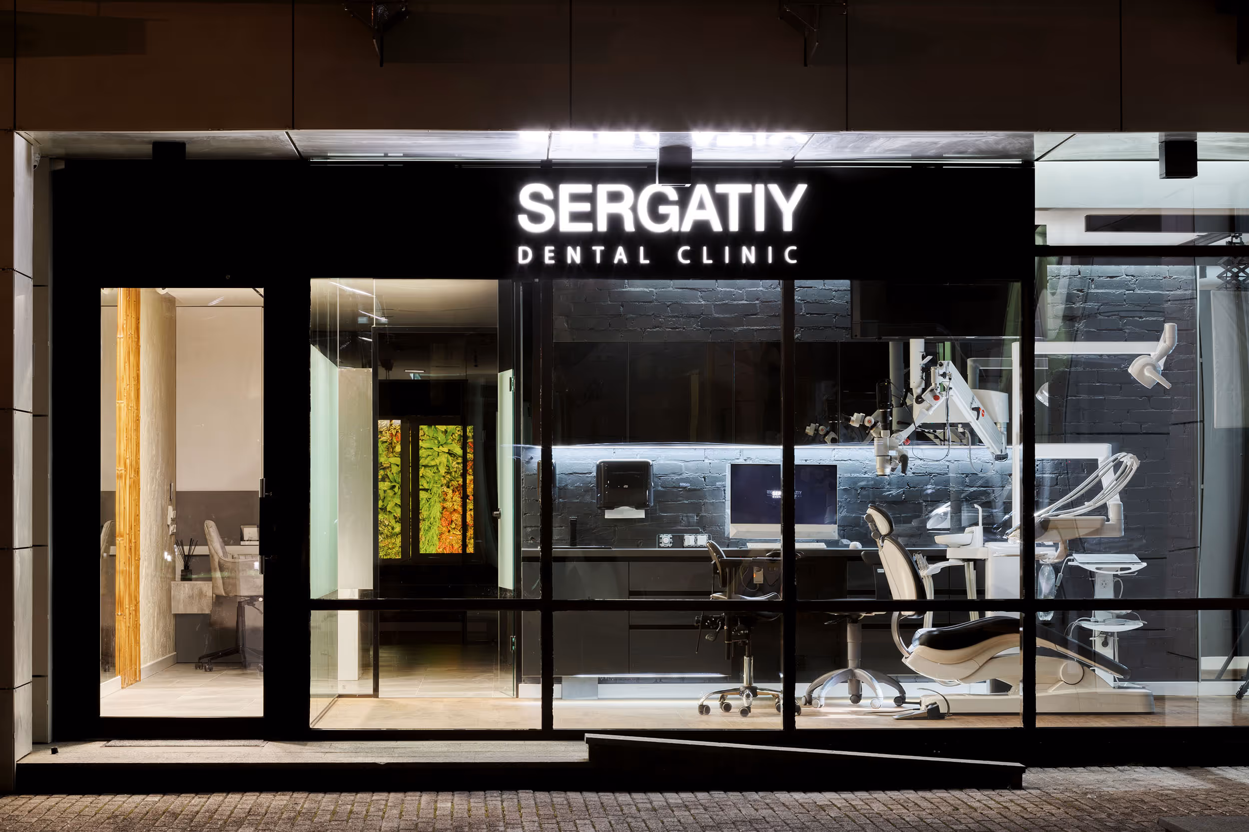 Фасад клініки Sergatiy Dental Clinic з панорамними вікнами, через які видно стерильні кабінети та сучасне обладнання.