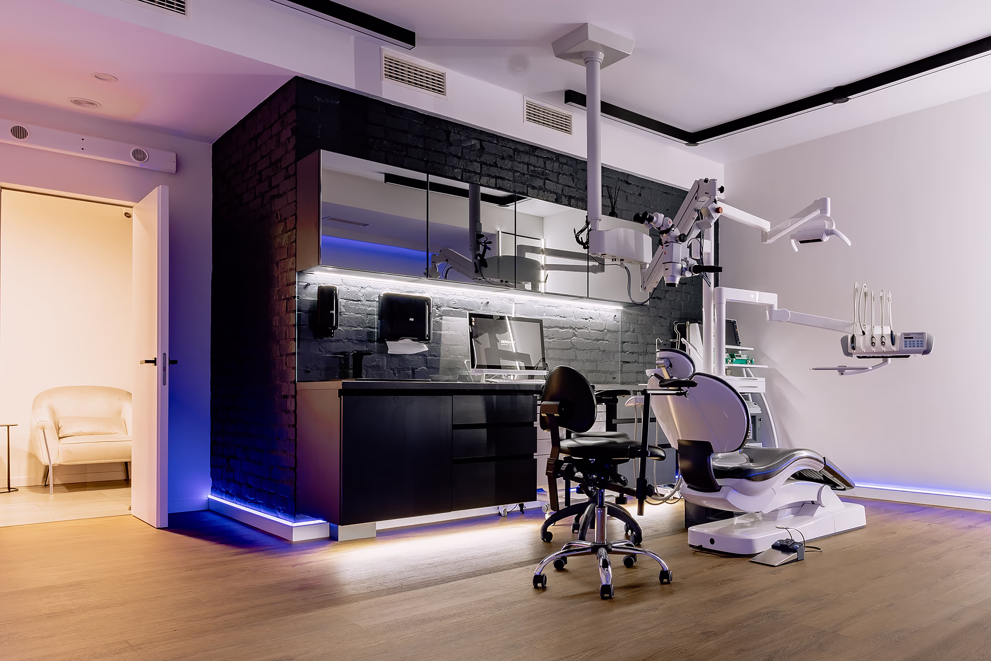 Сучасний кабінет Sergatiy Dental Clinic у Києві з стоматологічним кріслом, комп’ютером та інноваційним обладнанням у стильному інтер’єрі з підсвічуванням.