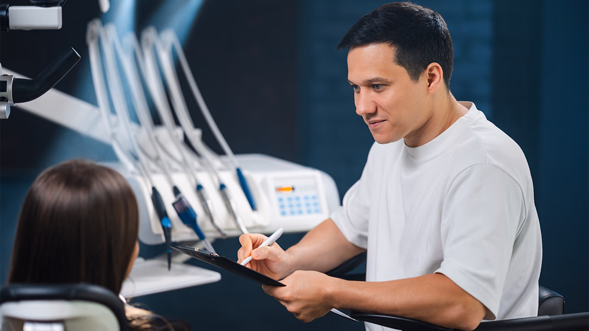 Стоматолог проводить консультацію та діагностику перед відбілюванням зубів. Оцінка стану емалі, наявності тріщин і старих пломб у клініці Sergatiy Dental Clinic, Печерськ, Київ.