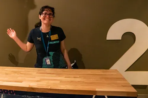 A smiling and waving MOPOP employee